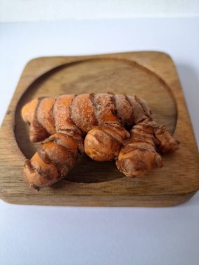 Tahta servis tahtasındaki zerdeçal ritmi. Zerdeçal öncelikle Asya mutfağında ve potansiyel sağlık yararları için yemek pişirmede bir baharat olarak kullanılır. Curcuma longa bitkisinin zencefille ilgili bir ritmi.