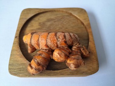 Tahta servis tahtasındaki zerdeçal ritmi. Zerdeçal öncelikle Asya mutfağında ve potansiyel sağlık yararları için yemek pişirmede bir baharat olarak kullanılır. Curcuma longa bitkisinin zencefille ilgili bir ritmi.