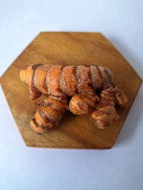 Tahta servis tahtasındaki zerdeçal ritmi. Zerdeçal öncelikle Asya mutfağında ve potansiyel sağlık yararları için yemek pişirmede bir baharat olarak kullanılır. Curcuma longa bitkisinin zencefille ilgili bir ritmi.