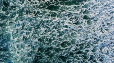 Yumuşak sabah ışığı, dağılmış ayak izleriyle işaretlenmiş el değmemiş kumları aydınlatır. Dalgaların sonsuz kobalt gökyüzünün altında kıyıda tur attığı yerde yalnızlık ve deniz tarafından sessiz bir yansıma hissi uyandırır..