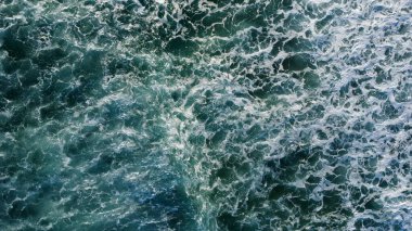 Yumuşak sabah ışığı, dağılmış ayak izleriyle işaretlenmiş el değmemiş kumları aydınlatır. Dalgaların sonsuz kobalt gökyüzünün altında kıyıda tur attığı yerde yalnızlık ve deniz tarafından sessiz bir yansıma hissi uyandırır..