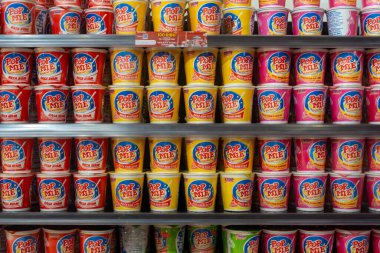 Bali, Endonezya - 22 Aralık 2024: Çeşitli erişteler de dahil olmak üzere raftaki abur cuburlar. Rafta bir sürü değişik erişte var.