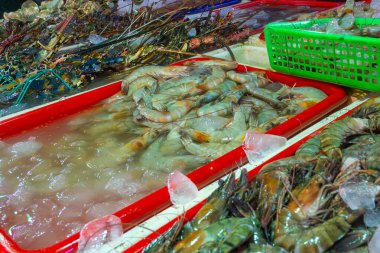Masada karidesli kırmızı tepsi var. Üzerinde karides olan başka tepsiler de var.