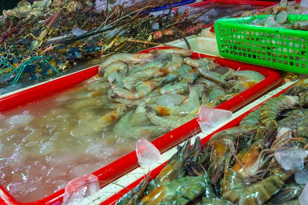 Masada karidesli kırmızı tepsi var. Üzerinde karides olan başka tepsiler de var.