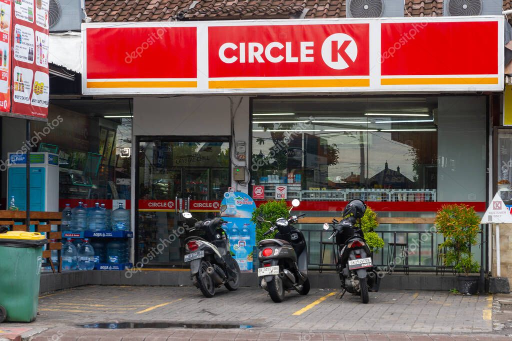 Bali, Indonesia - December 22, 2024: Circle K supermarket with a few motorcycles parked in the lot. The store is open and the parking lot is empty