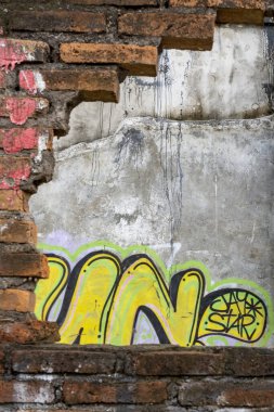 Bali, Endonezya - 10 Aralık 2024: Duvarda grafiti ve bir delik var. Grafiti çoğunlukla sarı ve mavi.