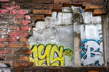 Bali, Endonezya - 10 Aralık 2024: Duvarda grafiti ve bir delik var. Grafiti çoğunlukla sarı ve mavi.