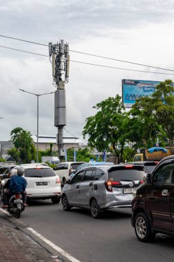 Bali, Endonezya - 10 Aralık 2024: Birçok araba ve motosikletle dolu bir cadde. Manzara kaotik ve hareketli. Bu görüntünün ana fikri yoğun trafiği olan bir şehir caddesi.