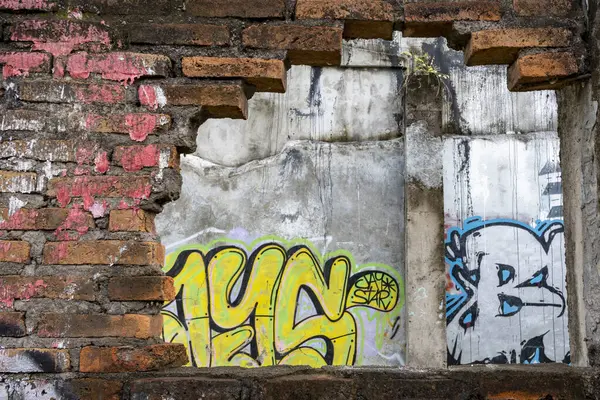 Bali, Endonezya - 10 Aralık 2024: Duvarda grafiti ve bir delik var. Grafiti çoğunlukla sarı ve mavi.