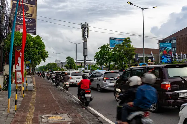 Bali, Endonezya - 10 Aralık 2024: Birçok araba ve motosikletle dolu bir cadde. Manzara kaotik ve hareketli. Bu görüntünün ana fikri yoğun trafiği olan bir şehir caddesi.