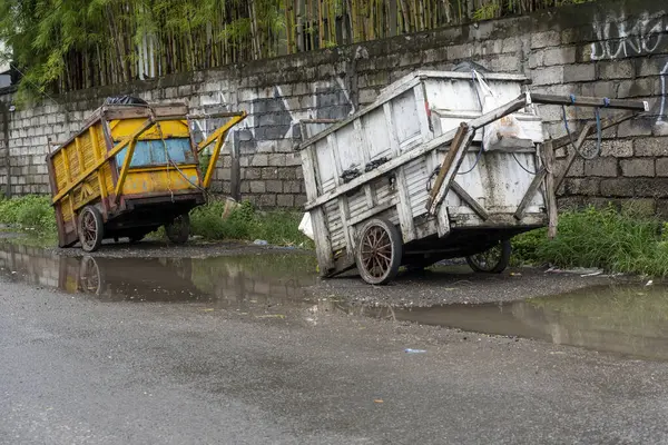 Bali, Endonezya - 28 Aralık 2024: Yolun kenarında iki çöp arabası duruyor. Biri sarı, diğeri beyaz.
