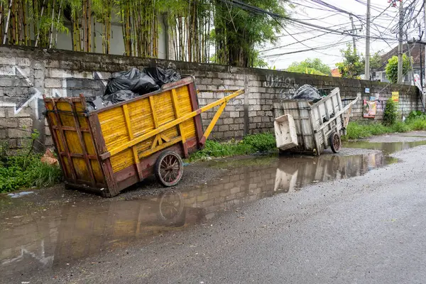 Bali, Endonezya - 28 Aralık 2024: Yolun kenarında iki çöp arabası duruyor. Biri sarı, diğeri beyaz.