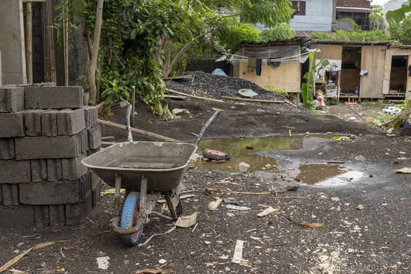 Gri el arabası inşaat halindeki bir binanın önünde.