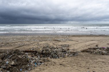 Bali, Endonezya - 28 Aralık 2024: sahil çöp ve enkazla kaplıydı. - Evet. Bir zamanlar güzel olan sahil kirlilik yüzünden harap oldu. Plaj plastik şişeler, plastik torbalar ve diğer çöp torbalarıyla dolu..