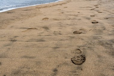 Plajda bir sürü ayakkabı izi var.