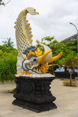 Bali, Endonezya - 11 Aralık 2024: Bali 'de bir balık heykeli. Heykel ağaçlar ve otlarla çevrili.