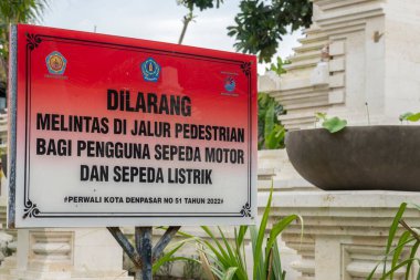 Bali, Endonezya - 17 Aralık 2024: Yabancı bir dilde imza atmak yayaları dikkatli olmaları konusunda uyarıyor. İşaret kırmızı ve beyaz.