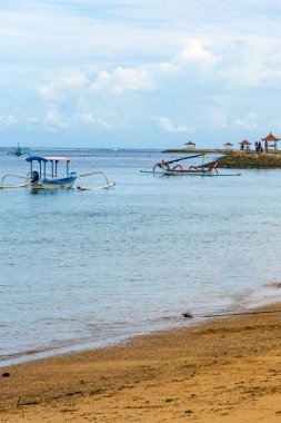 Bali, Endonezya - 17 Aralık 2024: Küçük mavi tekne suda duruyor. Gökyüzü bulutlu ve su sakin.