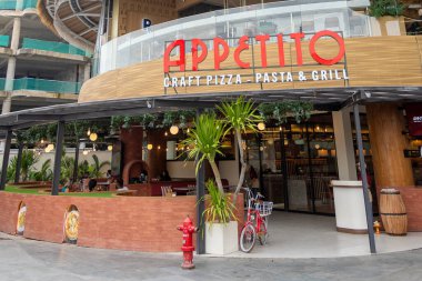 Bali, Endonezya - 17 Aralık 2024: Bali 'deki Icon Bali Alışveriş Merkezi. Appetito adlı restoranda kırmızı-beyaz bir tabela var. Restoranın bir verandası ve bisiklet parkı var.