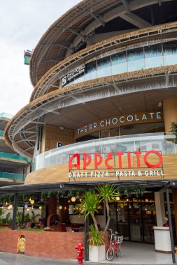 Bali, Endonezya - 17 Aralık 2024: Bali 'deki Icon Bali Alışveriş Merkezi. Appetito adlı restoranda kırmızı-beyaz bir tabela var. Restoranın bir verandası ve bisiklet parkı var.