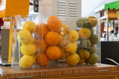 Cam bir kutuda meyve gösterimi. Meyve portakal, limon ve limon içerir.