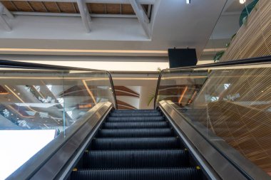 Alışveriş merkezinde siyah ve gümüş yürüyen merdiven. Yürüyen merdiven boş ve merdivenler siyah.