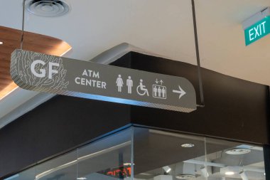 Bali, Endonezya - 17 Aralık 2024: Bali 'deki Icon Bali Alışveriş Merkezi. Tavandan sarkan tuvalet tabelasında bir adam, bir kadın ve bir çocuk vardı. İşaret sağı gösteriyor.
