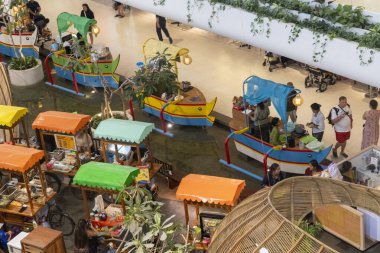 Bali, Endonezya - 17 Aralık 2024: Bali 'deki Icon Bali Alışveriş Merkezi. Icon Bali AVM 'deki renkli tezgah grubu. İnsanlar etrafta dolaşıp alışveriş yapıyorlar.