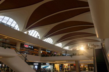 Bali, Endonezya - 17 Aralık 2024: Bali 'deki Icon Bali Alışveriş Merkezi. Etrafta bir sürü insanın dolaştığı büyük bir alışveriş merkezi. Alışveriş merkezinde bir sürü mağaza ve yürüyen merdiven var.