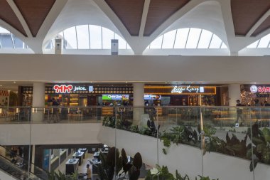 Bali, Endonezya - 17 Aralık 2024: Bali 'deki Icon Bali Alışveriş Merkezi. Etrafta bir sürü insanın dolaştığı büyük bir alışveriş merkezi. Alışveriş merkezinde bir sürü mağaza ve yürüyen merdiven var.
