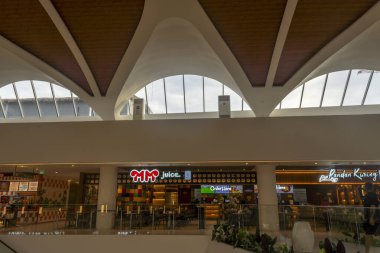 Bali, Endonezya - 17 Aralık 2024: Bali 'deki Icon Bali Alışveriş Merkezi. Etrafta bir sürü insanın dolaştığı büyük bir alışveriş merkezi. Alışveriş merkezinde bir sürü mağaza ve yürüyen merdiven var.