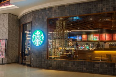 Bali, Endonezya - 17 Aralık 2024: Trans Studio Mall, Bali. Alışveriş merkezinde geniş pencereli Starbucks restoranı