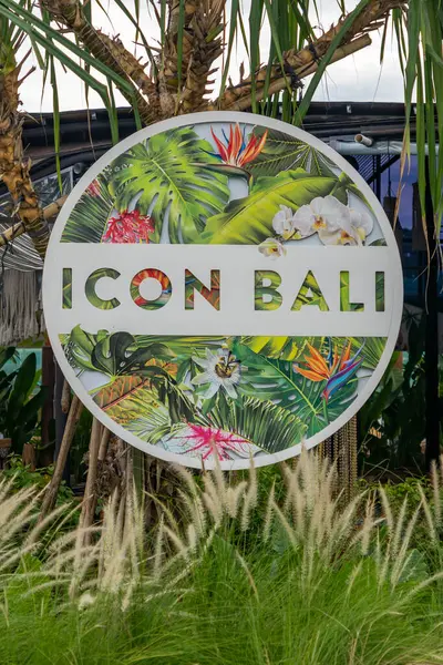 Bali, Endonezya - 17 Aralık 2024: Icon Bali Alışveriş Merkezi 'nin imzası yemyeşil bir alanda gösterildi. Tabela uzun otlar ve palmiye ağaçları ile çevrilidir. İşaret beyaz ve yeşil, tropikal bir tasarımı var.