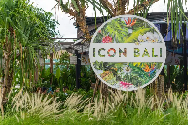 Bali, Endonezya - 17 Aralık 2024: Icon Bali Alışveriş Merkezi 'nin imzası yemyeşil bir alanda gösterildi. Tabela uzun otlar ve palmiye ağaçları ile çevrilidir. İşaret beyaz ve yeşil, tropikal bir tasarımı var.