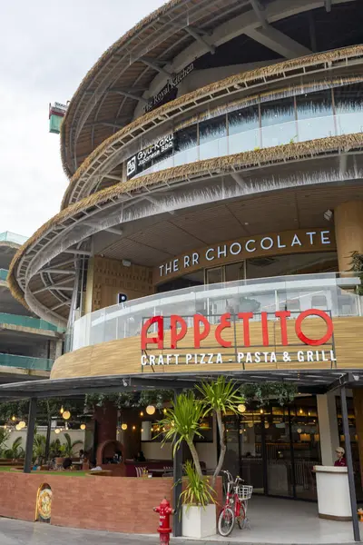 Bali, Endonezya - 17 Aralık 2024: Bali 'deki Icon Bali Alışveriş Merkezi. Appetito adlı restoranda kırmızı-beyaz bir tabela var. Restoranın bir verandası ve bisiklet parkı var.