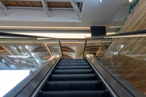 Alışveriş merkezinde siyah ve gümüş yürüyen merdiven. Yürüyen merdiven boş ve merdivenler siyah.