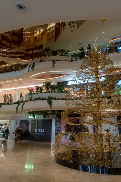 Bali, Endonezya - 17 Aralık 2024: Bali 'deki Icon Bali Alışveriş Merkezi. Büyük bir Noel ağacı alışveriş merkezinin ortasında. Alışveriş merkezi insanlarla dolu ve bir Boss mağazası da dahil olmak üzere çeşitli mağazaları var.