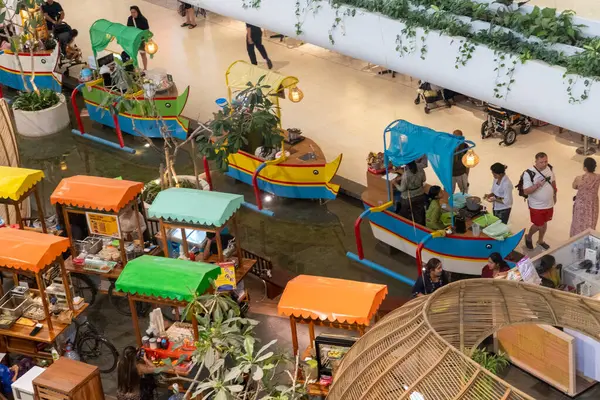 Bali, Endonezya - 17 Aralık 2024: Bali 'deki Icon Bali Alışveriş Merkezi. Icon Bali AVM 'deki renkli tezgah grubu. İnsanlar etrafta dolaşıp alışveriş yapıyorlar.