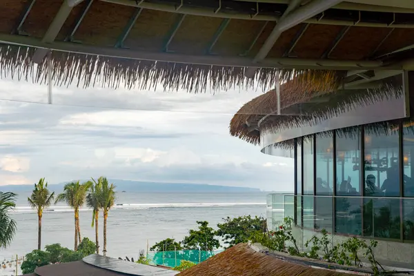 Bali, Endonezya - 17 Aralık 2024: Bali 'deki Icon Bali Alışveriş Merkezi. Arka planda palmiye ağaçları olan bir balkondan okyanus manzarası. Manzara huzurlu ve rahatlatıcı.