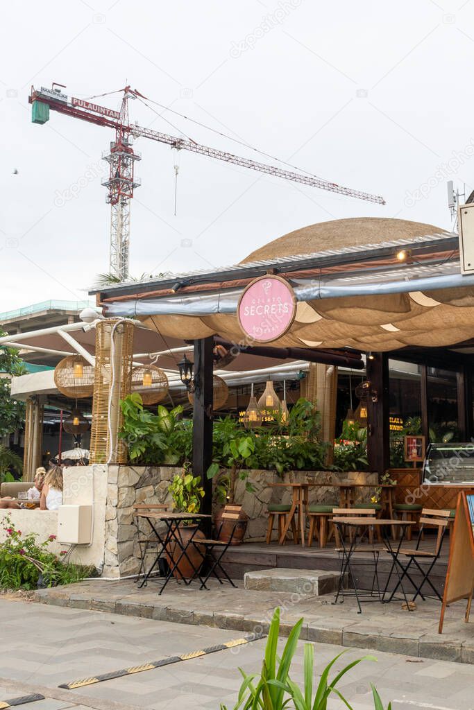 Bali, Indonesia - Dec 17, 2024: Restaurant with a sign that says L OSTERIA. There are several tables and chairs outside