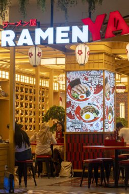 Bali, Endonezya - 17 Aralık 2024: Trans Studio Mall, Bali. Masalarda insanların oturduğu Ramen restoranı. Restoran aydınlık ve üzerinde 