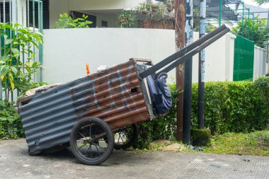 Jakarta, Endonezya - 9 Şubat 2025: içinde bir sürü ıvır zıvır olan paslı araba. Araba bir avluya park edilmiş.