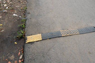 Yolun ortasında siyah ve sarı hız tümsekleri