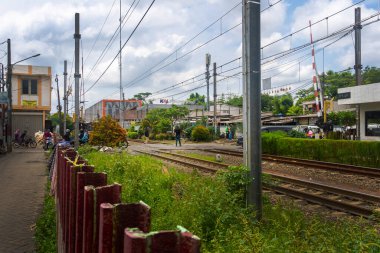 Jakarta, Endonezya - 9 Şubat 2025: Trafiğin yoğun olduğu tren yolu. Raylarda arabalar ve motosikletler var. Pondok Ranji tren istasyonu, Jakarta.
