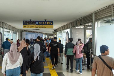 Jakarta, Endonezya - 9 Şubat 2025: Bir grup insan bir tren istasyonunda yürüyor. Sahne meşgul ve hareketli.