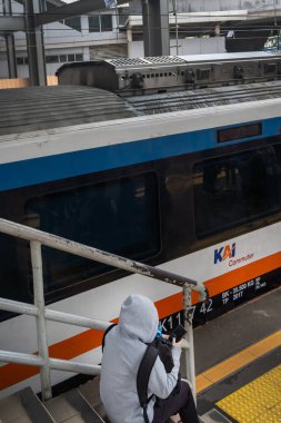 Jakarta, Endonezya - 9 Şubat 2025: Adam bir tren platformunda oturuyor
