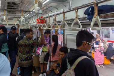 Jakarta, Endonezya - 9 Şubat 2025: Tek boynuzlu at sırt çantalı bir adamla dolu metro treni trenin ortasında duruyor.
