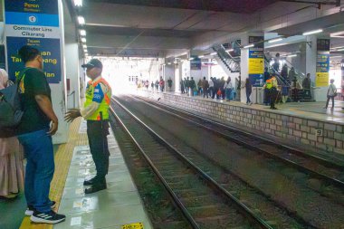 Jakarta, Endonezya - 9 Şubat 2025: Uzun platformlu ve üzerinde bir sürü insan olan tren istasyonu. Platform boş ve tren görünmüyor. Manggarai tren istasyonu.