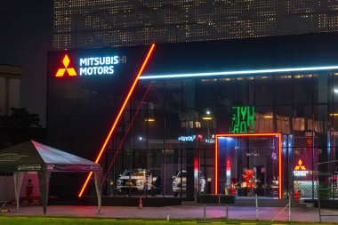 Jakarta, Endonezya - 9 Şubat 2025: neon ışıklı Mitsubishi Motor binası. Bina gece aydınlanıyor.
