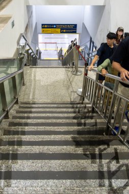 Jakarta, Endonezya - 9 Şubat 2025: Manggarai tren istasyonunda bir grup insan merdivenlerde yürüyor. Merdivenler metalden yapılmıştır ve bir platformun yakınındadır..